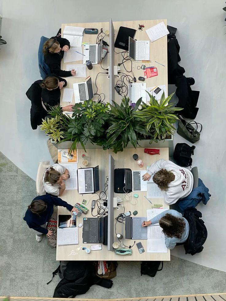 Equipo de empresa trabajando coordinadamente con laptops en oficina abierta